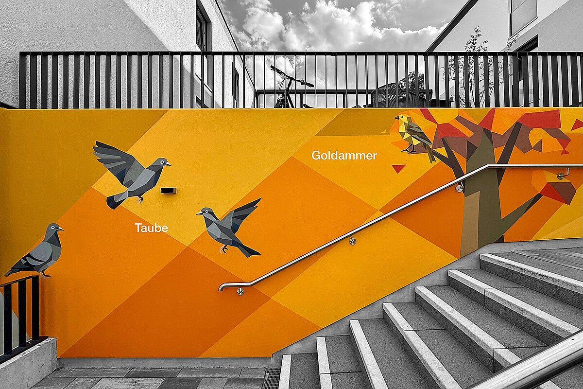Orangefarbene Fassadenkunst an einer Treppe der Erlenhöfe Jena mit Tauben und einer Goldammer.