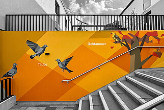 Orangefarbene Fassadenkunst an einer Treppe der Erlenhöfe Jena mit Tauben und einer Goldammer.