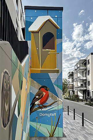 Farbige Fassadenkunst in den Erlenhöfen Jena mit Dompfaff, Vogelhaus und weiteren Tiermotiven an einer Treppenanlage.