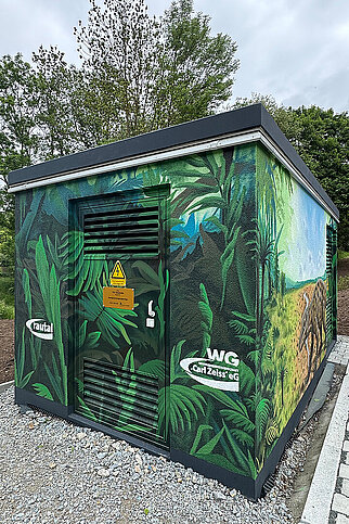 Bemalte Technikstation in den Erlenhöfen Jena mit detailreicher Pflanzenlandschaft und naturbezogener Fassadengestaltung.