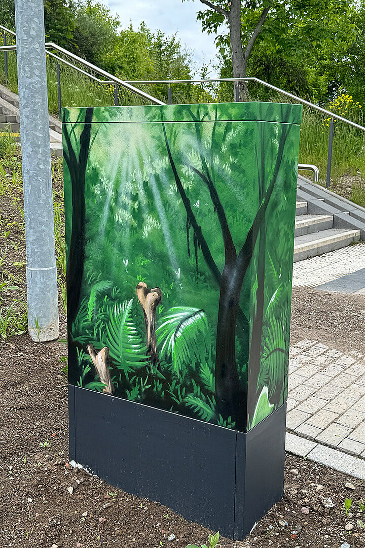 Bemalter Verteilerkasten in den Erlenhöfen Jena mit grünem Waldmotiv und dichter Pflanzenwelt.